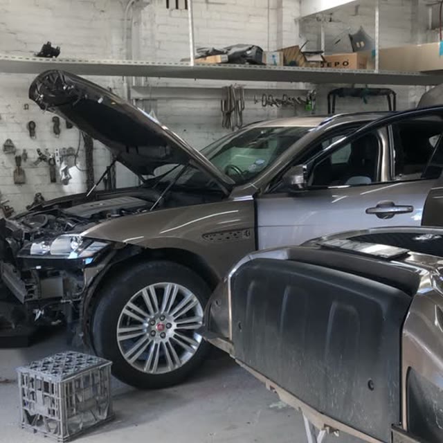 Two vehicles positioned for repair inside the Cammeray Smash Repairs workshop