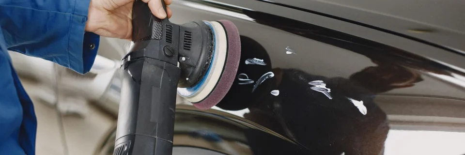 Representative photo: hands guiding a power polisher on a car panel